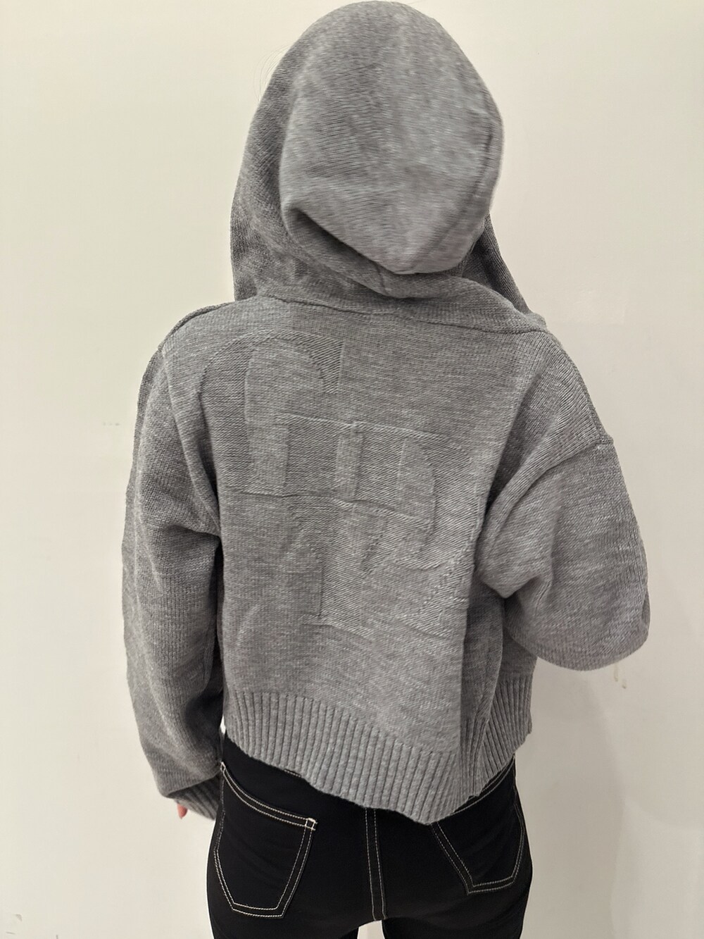 グレー系のパーカー、ブラック系のキャミソール、ブラック系のデニムパンツを着用したレディースの夏コーディネートの6枚目の写真