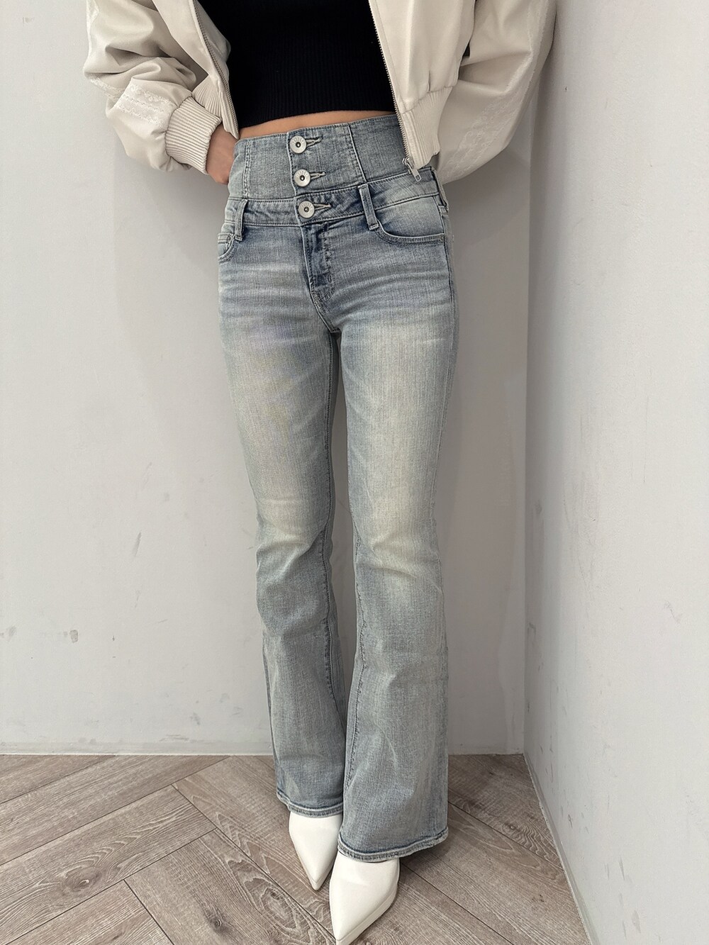 ブルー系のデニムパンツ、ホワイト系のパンプス、ホワイト系のスウェットを着用したレディースの冬コーディネートの7枚目の写真