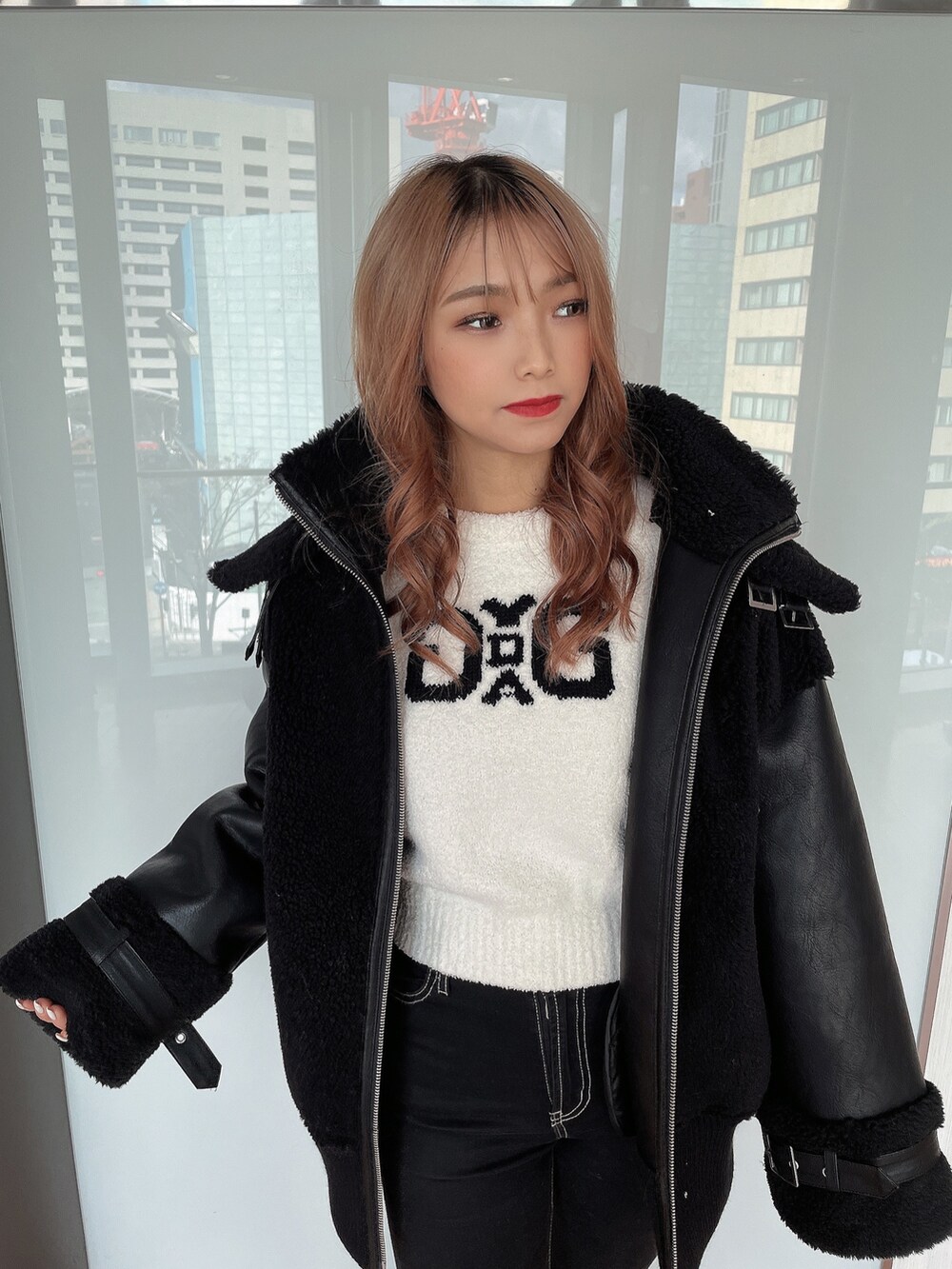 ホワイト系のニット/セーター、ブラック系のブルゾン、ブラック系のデニムパンツを着用したレディースの冬コーディネートの4枚目の写真