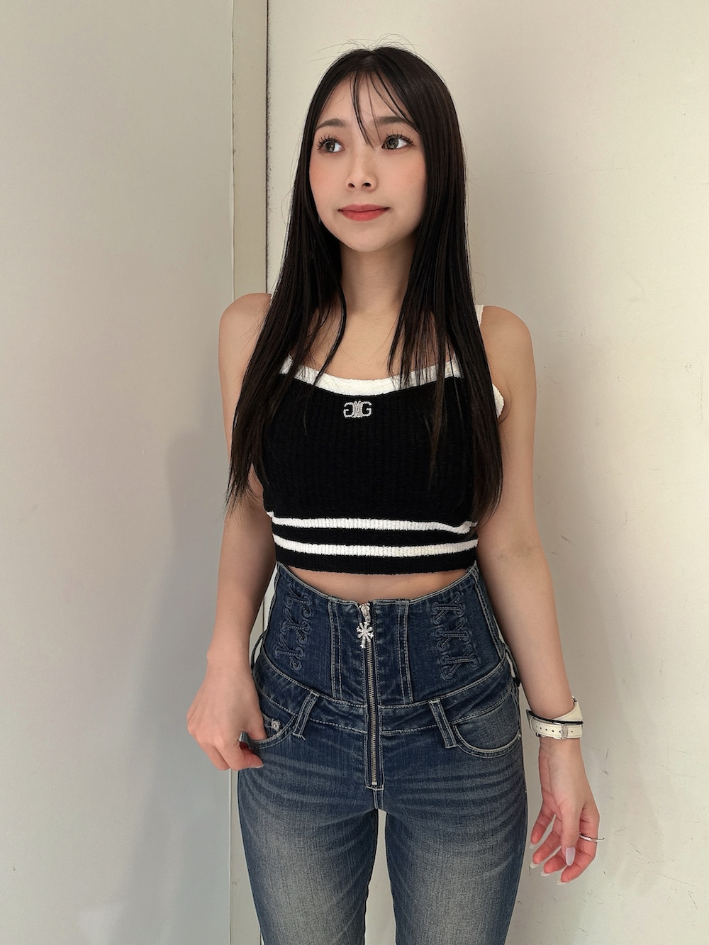 ブルー系のデニムパンツ、ブラック系のキャミソール、ブラック系のサンダルを着用したレディースの春コーディネートの4枚目の写真