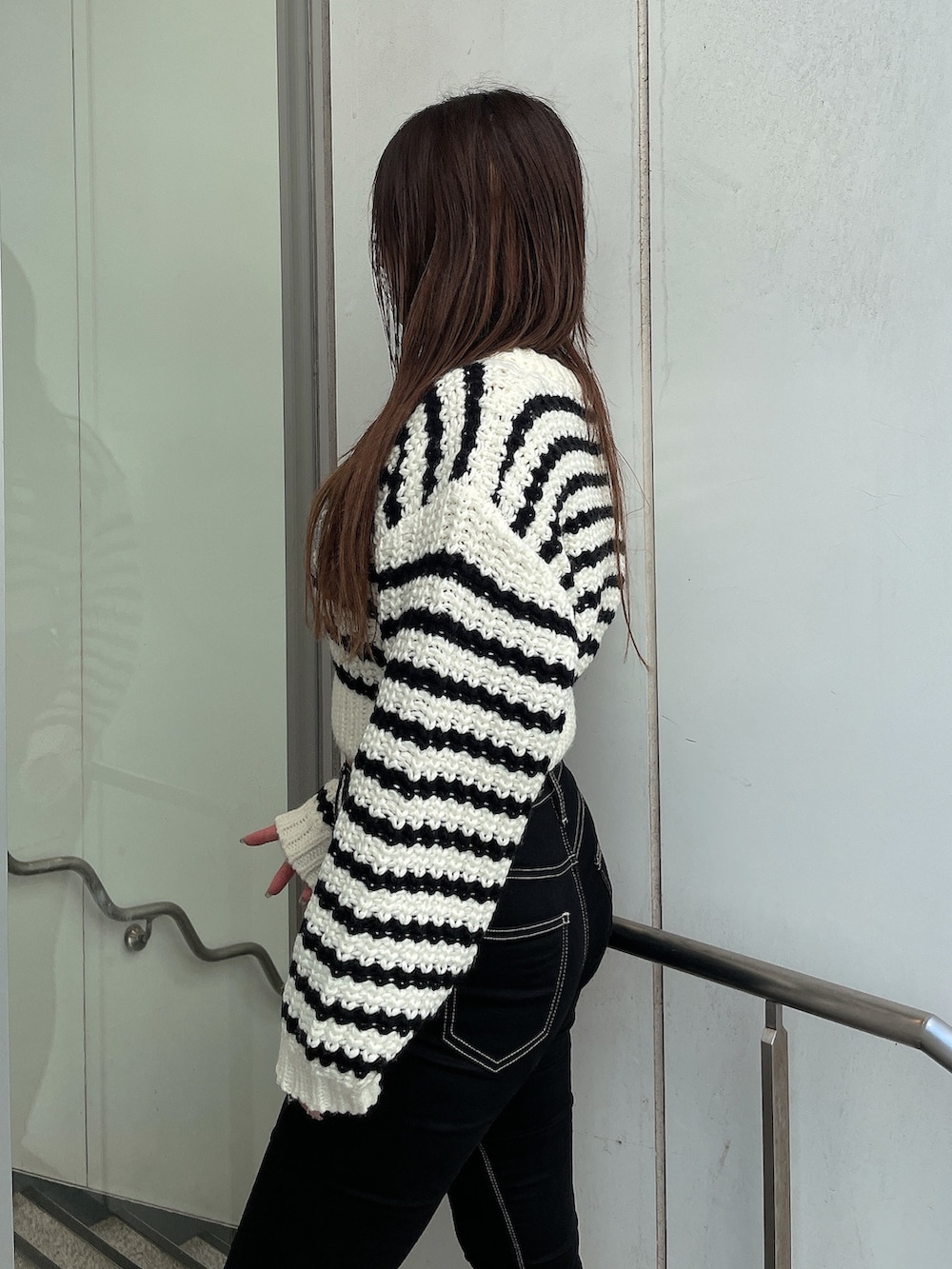 その他のカーディガン/ボレロ、ブラック系のデニムパンツ、ブラック系のブーツを着用したレディースの秋コーディネートの5枚目の写真
