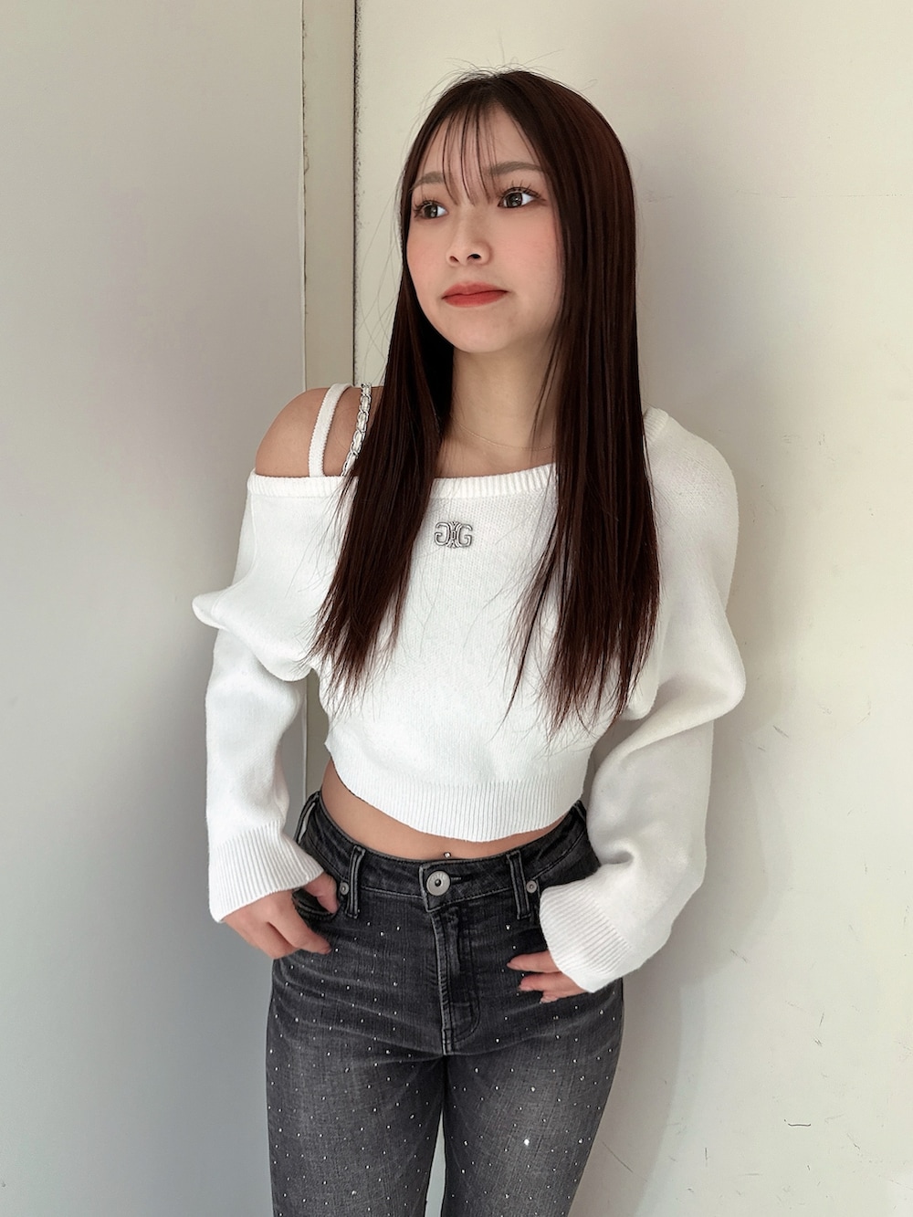 ブラック系のデニムパンツ、ブラック系のブーツ、ホワイト系のニット/セーターを着用したレディースの冬コーディネートの4枚目の写真