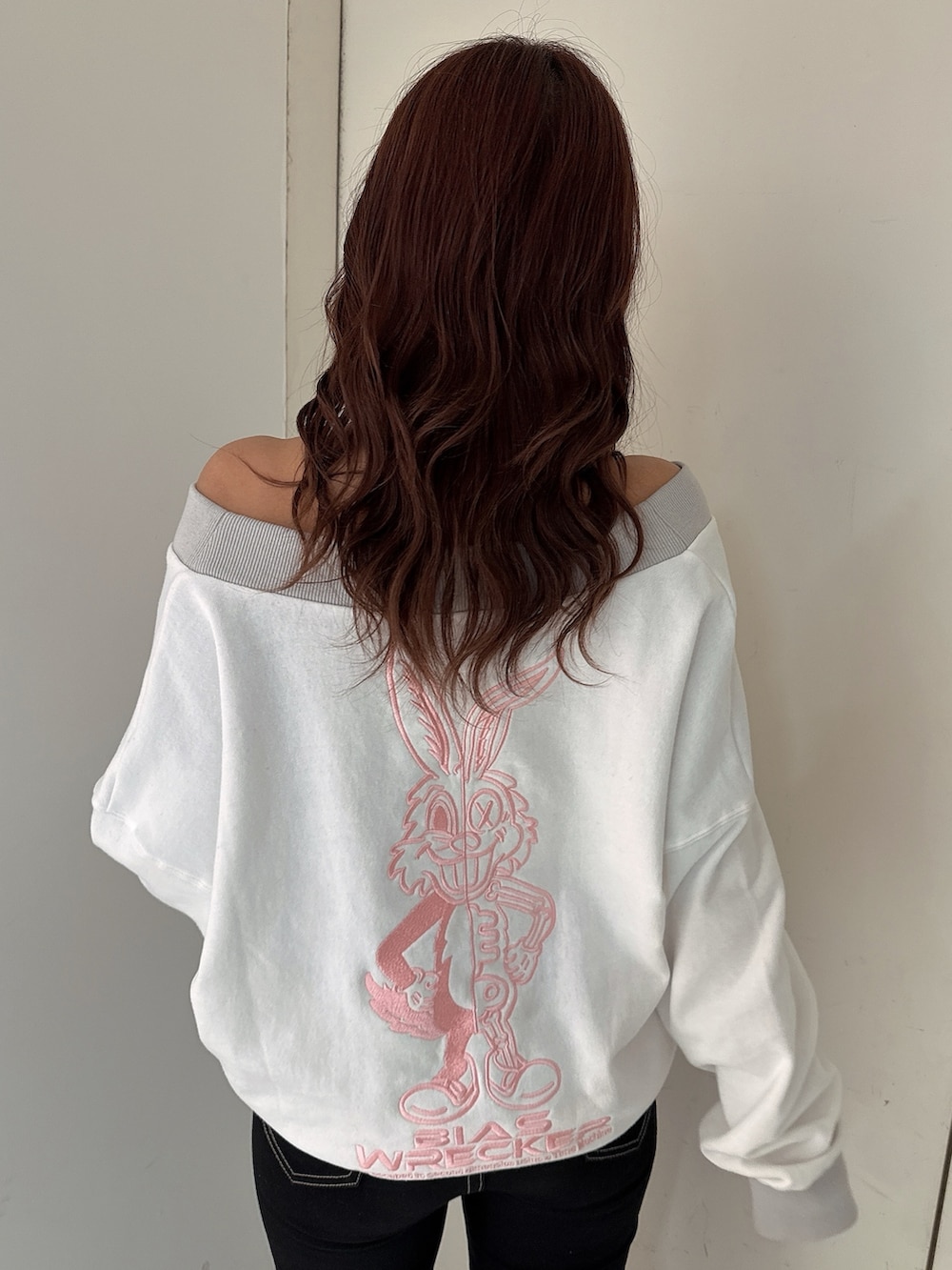 ブラック系のデニムパンツ、ホワイト系のスウェット、ホワイト系のパンプスを着用したレディースの冬コーディネートの6枚目の写真