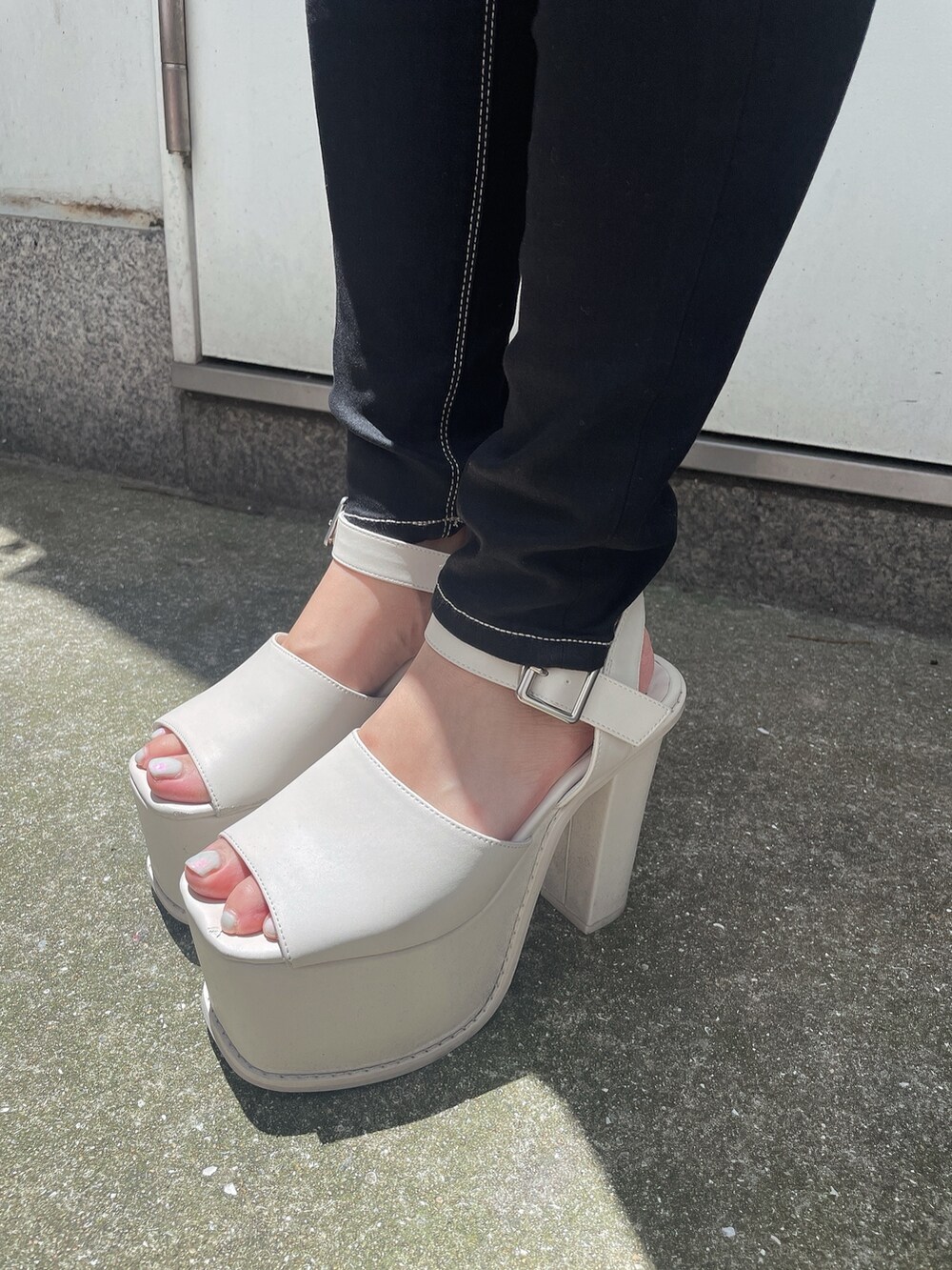 ブルー系のデニムパンツ、ホワイト系のサンダルを着用したレディースの春コーディネートの9枚目の写真