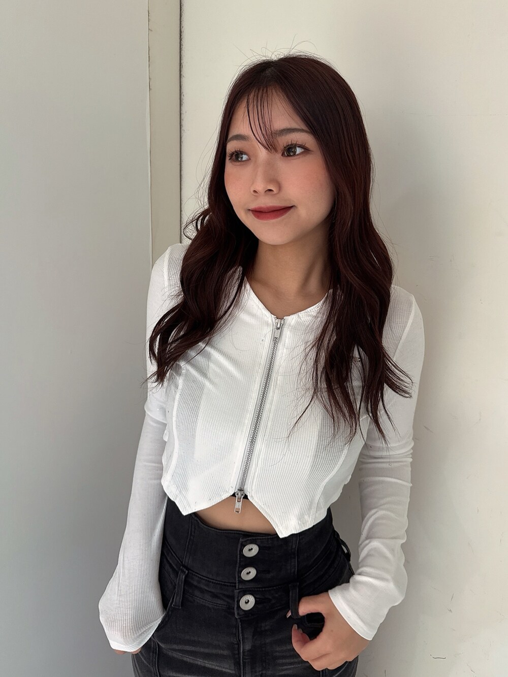 ブラック系のデニムスカート、ブラック系のTシャツ/カットソー、ホワイト系のパンプスを着用したレディースの秋コーディネートの4枚目の写真