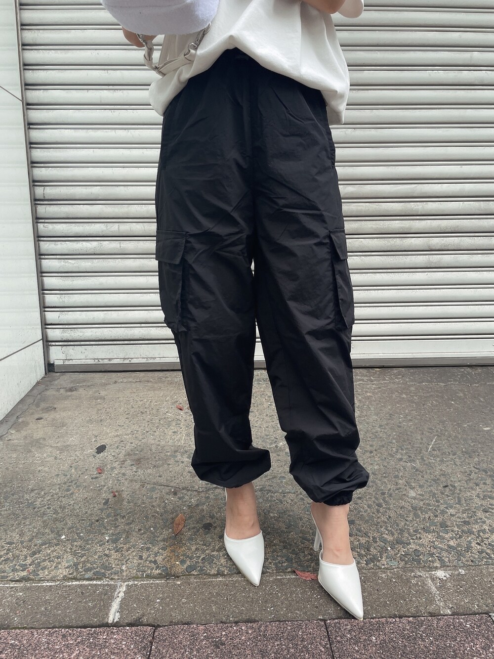 ホワイト系のバックパック/リュック、ホワイト系のTシャツ/カットソー、ブラック系のカーゴパンツを着用したレディースの夏コーディネートの7枚目の写真