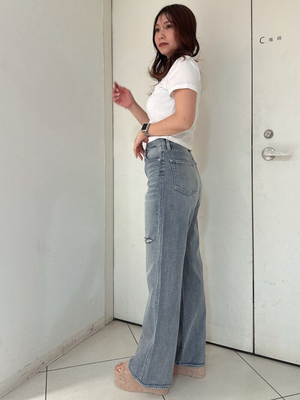 ホワイト系のサンダル、ホワイト系のTシャツ/カットソー、ブルー系のデニムパンツを着用したレディースの春コーディネートの2枚目の写真