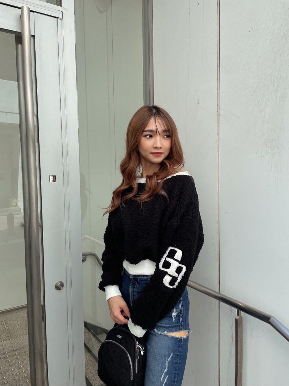 ブラック系のパンプス、ブラック系のTシャツ/カットソー、ブルー系のデニムパンツを着用したレディースの秋コーディネートの2枚目の写真