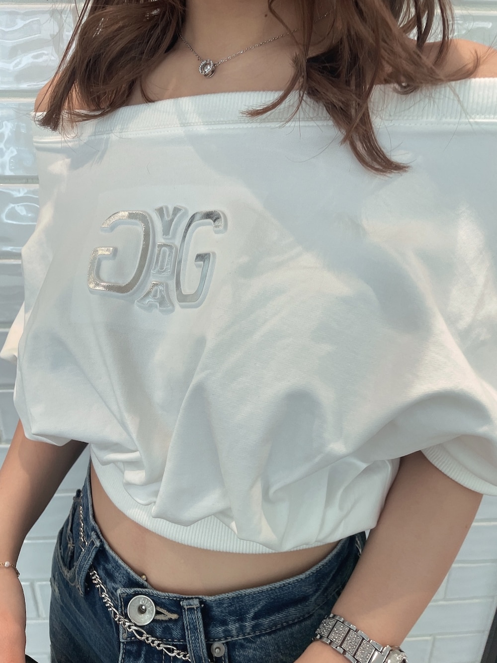 ブルー系のデニムパンツ、ブラック系のハンドバッグ、ブラック系のサンダルを着用したレディースの春コーディネートの5枚目の写真