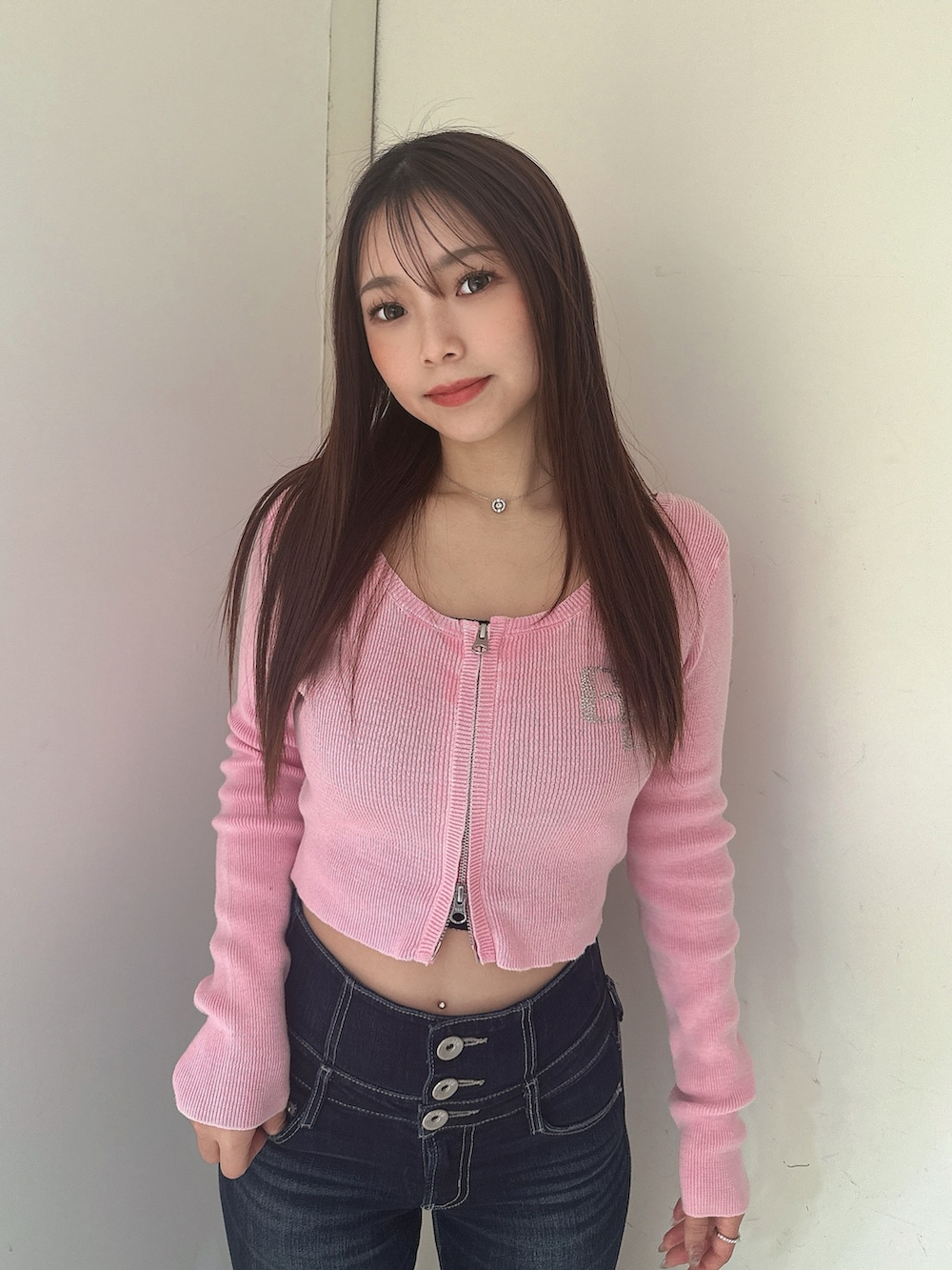 ブルー系のデニムパンツ、ブラック系のサンダル、ピンク系のニット/セーターを着用したレディースの春コーディネートの4枚目の写真