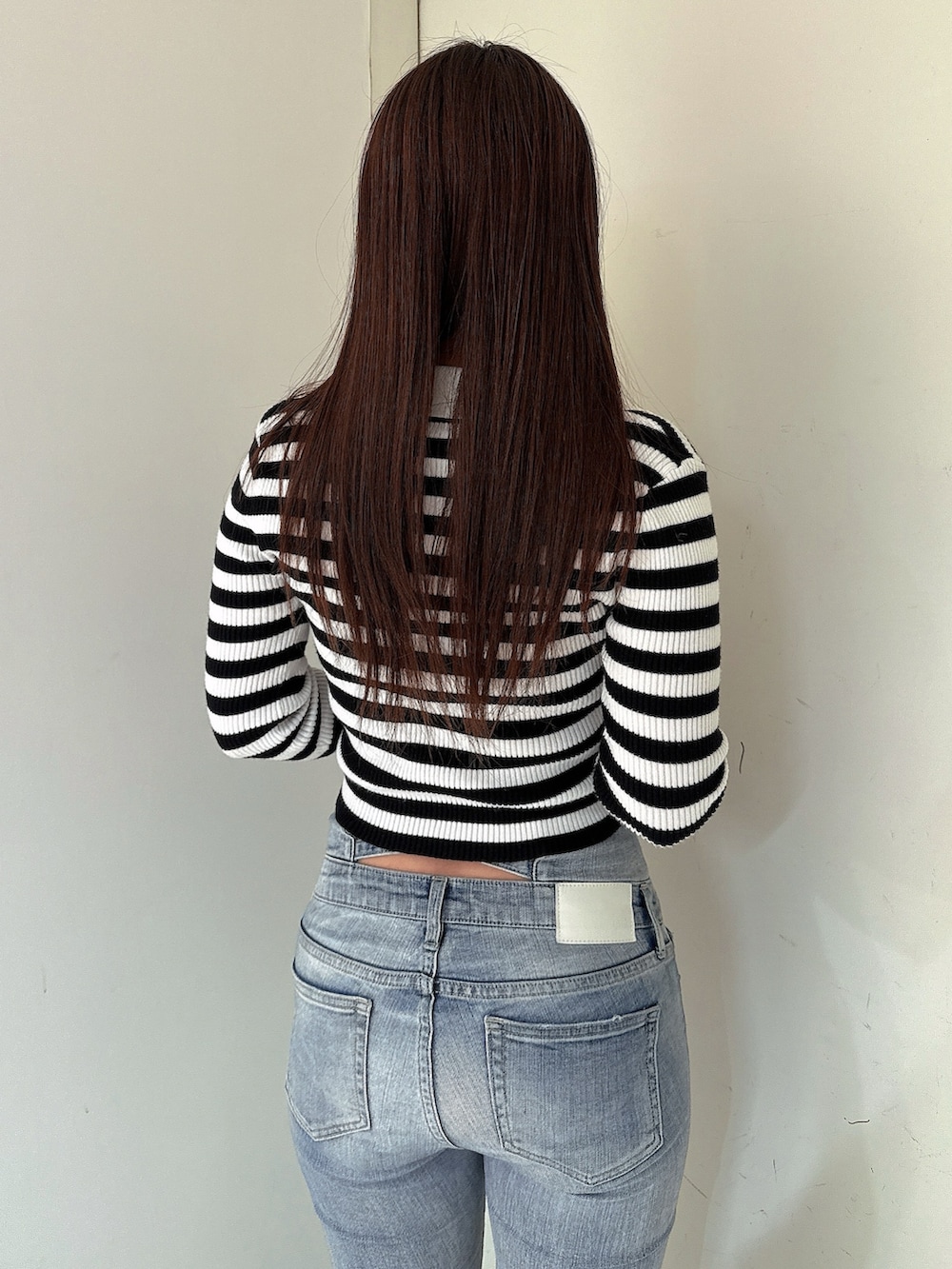 ブルー系のデニムパンツ、ブラック系のブーツ、その他のニット/セーターを着用したレディースの冬コーディネートの6枚目の写真