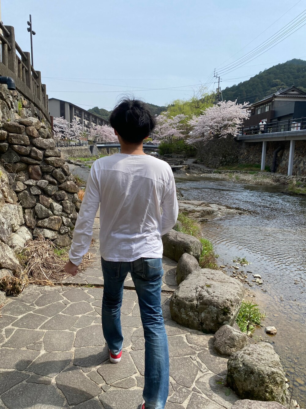 ホワイト系のトップス、ブルー系のデニムパンツ、ブルー系のシャツ/ブラウスを着用したメンズの春コーディネートの2枚目の写真