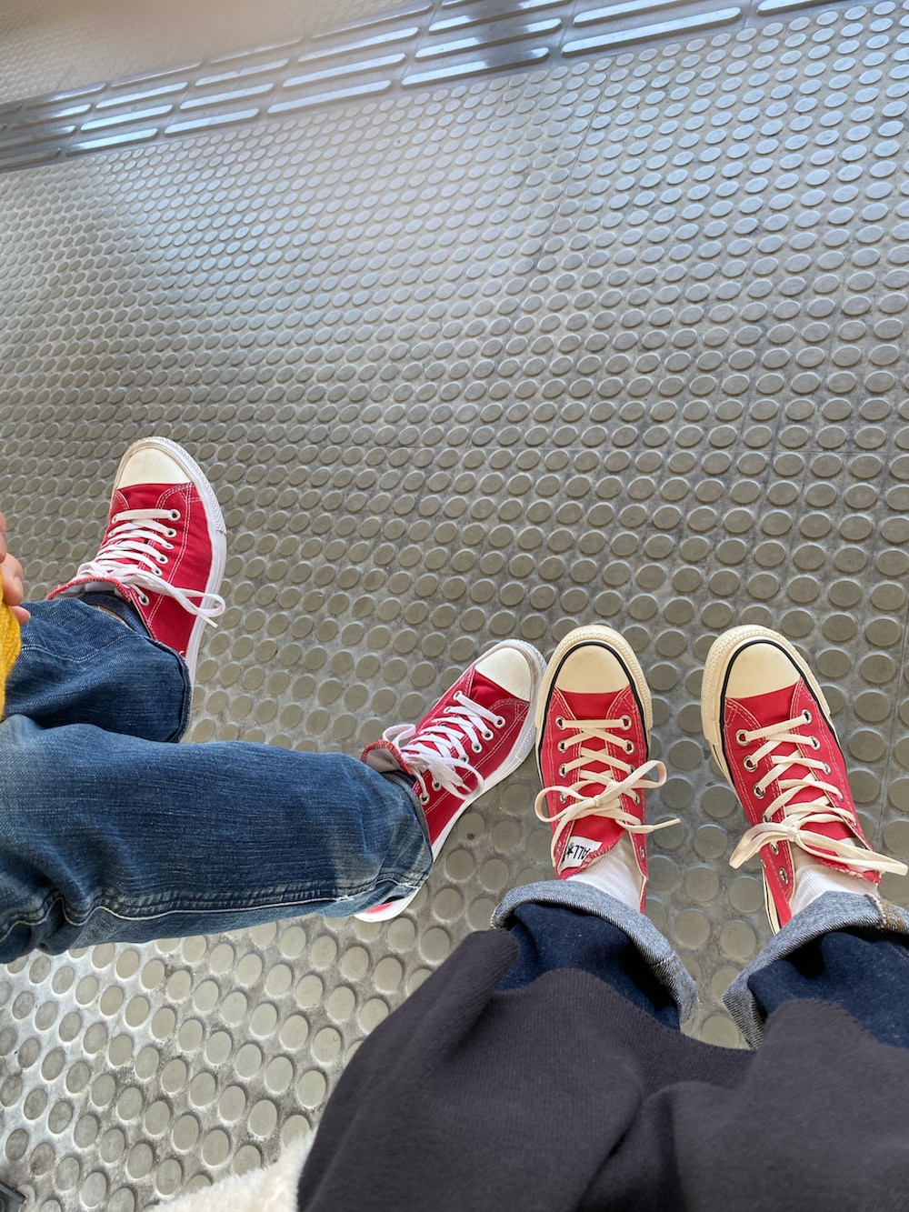 イエロー系のカーディガン/ボレロ、レッド系のトップス、ブルー系のデニムパンツを着用したメンズの冬コーディネートの3枚目の写真