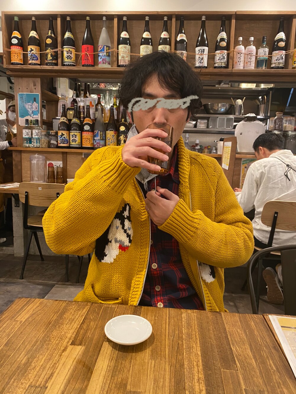 イエロー系のカーディガン/ボレロ、レッド系のトップス、ブルー系のデニムパンツを着用したメンズの冬コーディネートの2枚目の写真