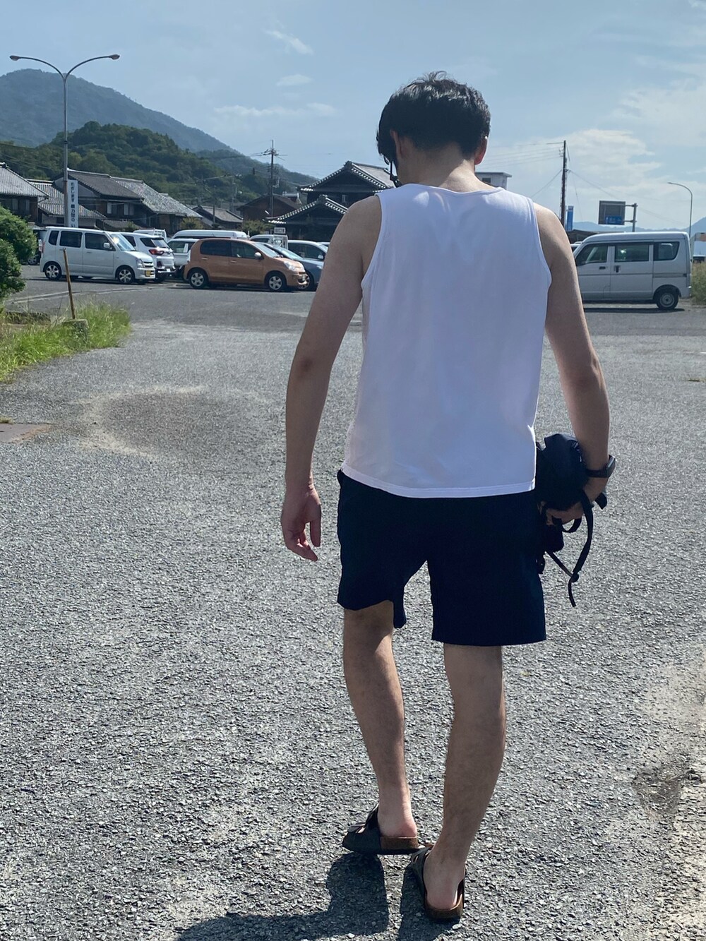 ブルー系のセットアップ、ブラック系のサンダル、ホワイト系のタンクトップを着用したメンズの秋コーディネートの3枚目の写真