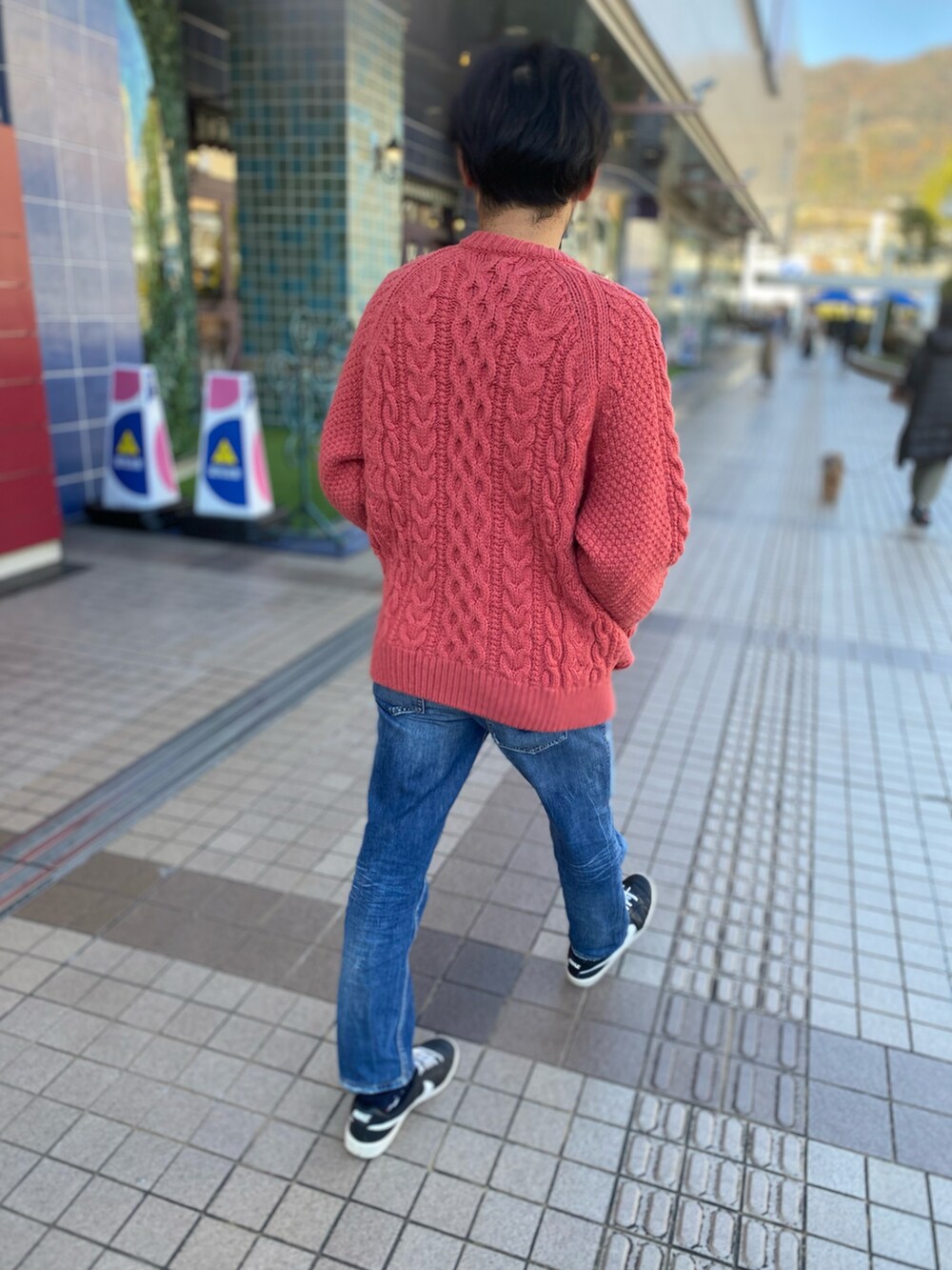 ピンク系のカーディガン/ボレロ、ブルー系のデニムパンツを着用したメンズの冬コーディネートの2枚目の写真