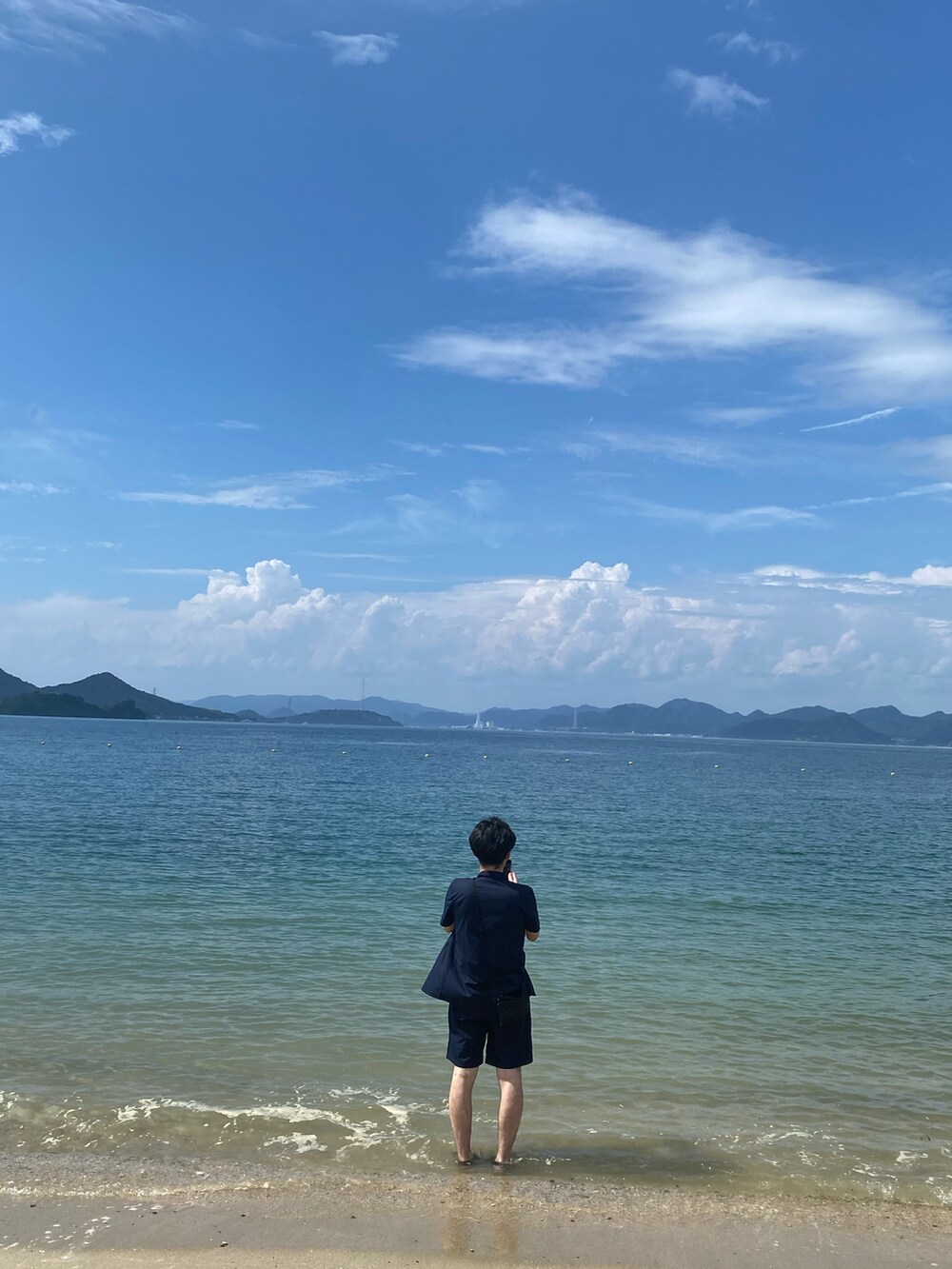 ブルー系のセットアップ、ブラック系のサンダル、ホワイト系のタンクトップを着用したメンズの秋コーディネートの2枚目の写真