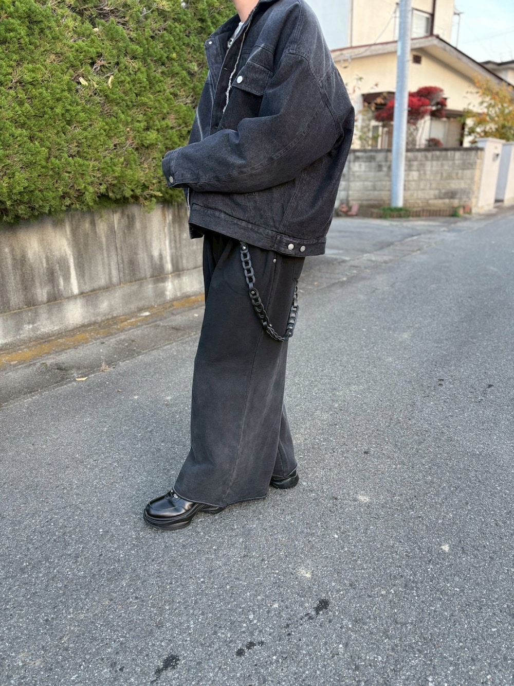 グレー系のスウェット、ブラック系のデニムジャケット、ブラック系のスウェットパンツを着用したメンズの秋コーディネートの2枚目の写真