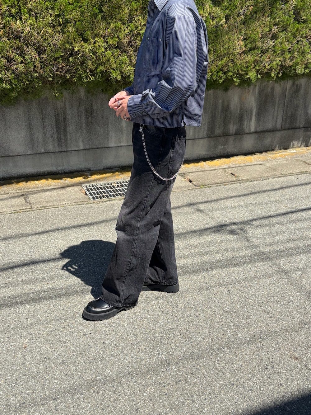 ブラック系のデニムパンツ、ブラック系のシャツ/ブラウス、ブラック系のローファーを着用したメンズの春コーディネートの2枚目の写真