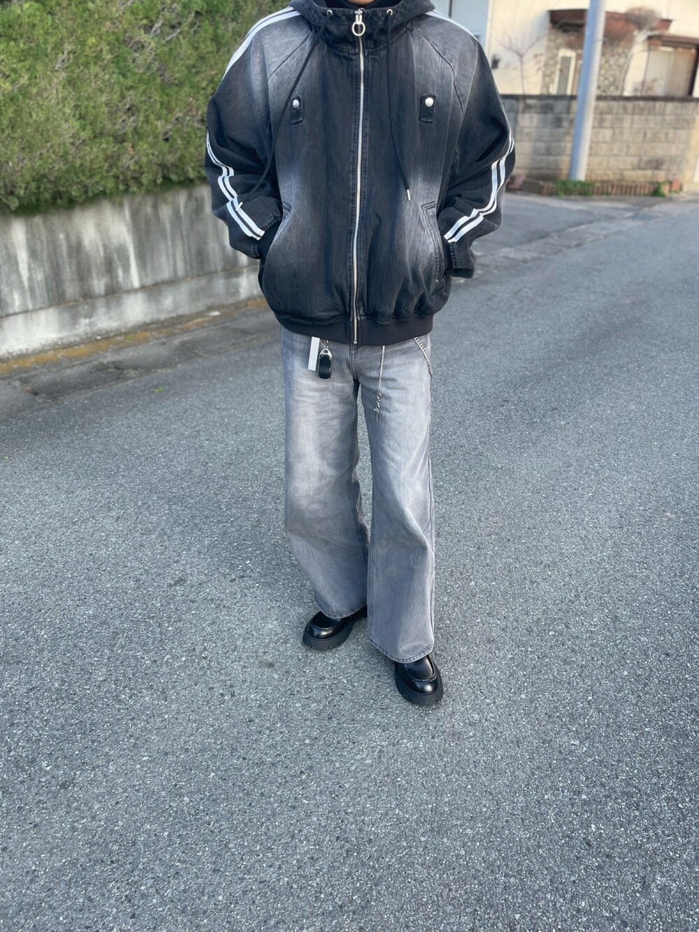 グレー系のデニムパンツ、ブラック系のブルゾン、ブラック系のローファーを着用したメンズの冬コーディネートの2枚目の写真