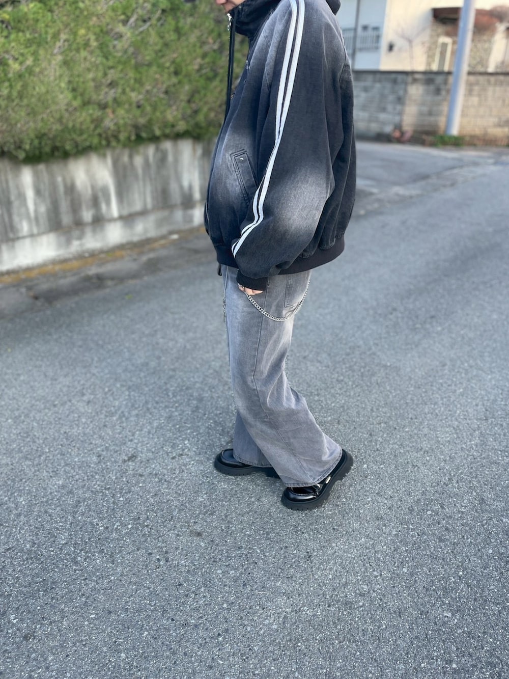 グレー系のデニムパンツ、ブラック系のブルゾン、ブラック系のローファーを着用したメンズの冬コーディネートの3枚目の写真