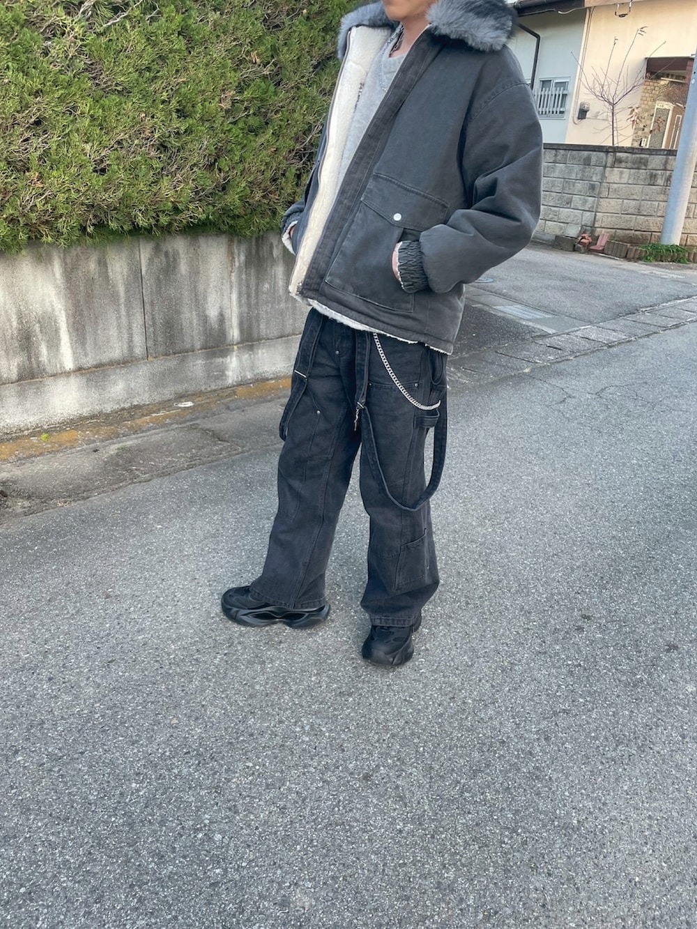 グレー系のニット/セーター、ブラック系のブルゾン、ブラック系のデニムパンツを着用したメンズの冬コーディネートの2枚目の写真