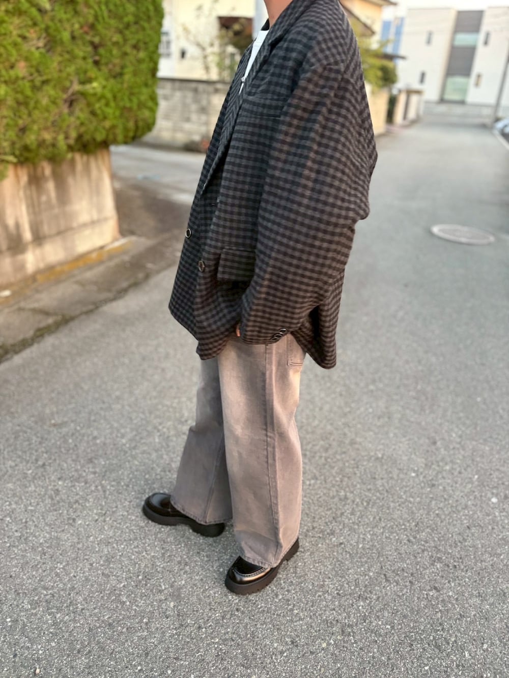 ブラック系のテーラードジャケット、グレー系のデニムパンツ、ブラック系のローファーを着用したメンズの秋コーディネートの2枚目の写真