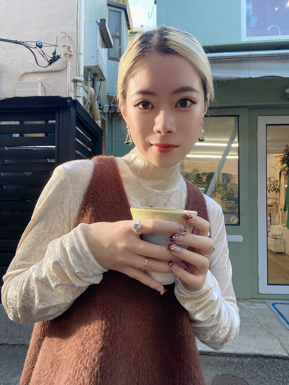 ブラウン系のベスト、ホワイト系のトップス、ブラック系のパンツを着用したレディースの冬コーディネートの2枚目の写真