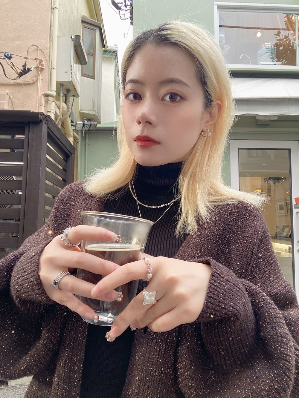 ブラック系のトップス、ブラウン系のカーディガン/ボレロ、シルバー系のネックレスを着用したレディースの冬コーディネートの4枚目の写真