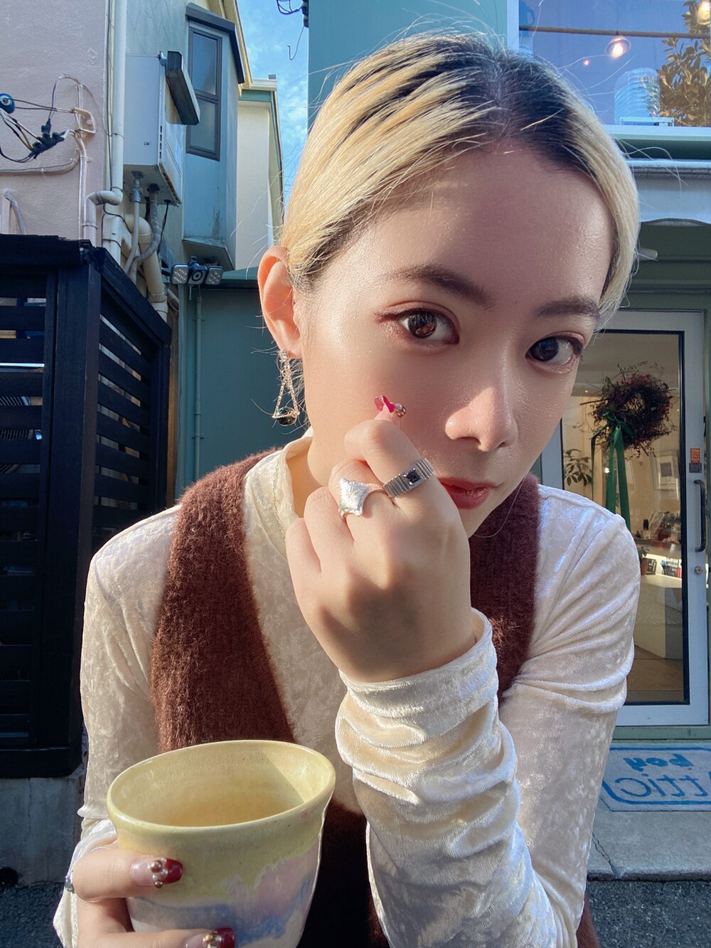 ブラウン系のベスト、ホワイト系のトップス、ブラック系のパンツを着用したレディースの冬コーディネートの3枚目の写真