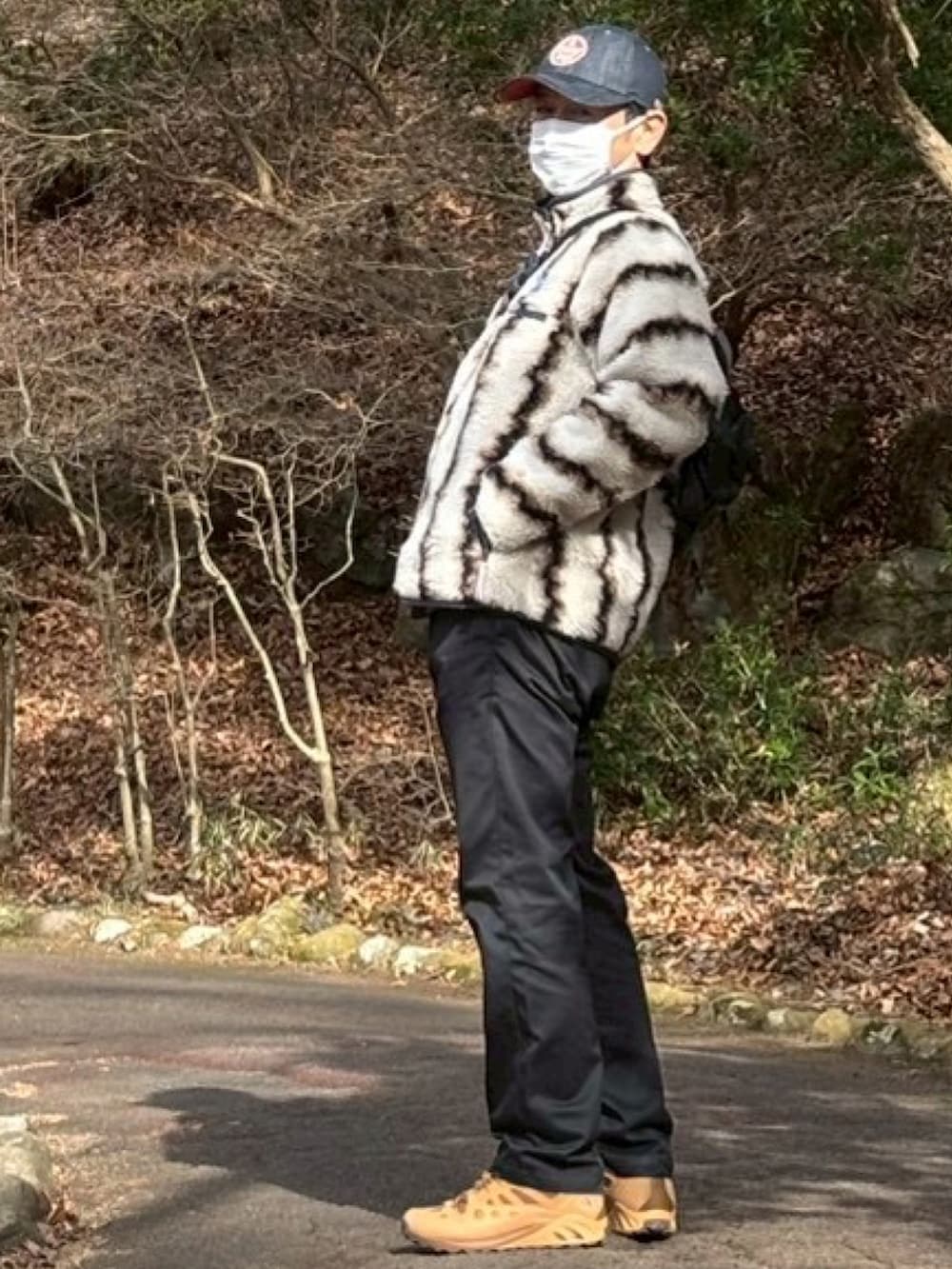 ベージュ系のブルゾン、ブラック系のチノパンツ、ブラウン系のスニーカーを着用したメンズの冬コーディネートの2枚目の写真