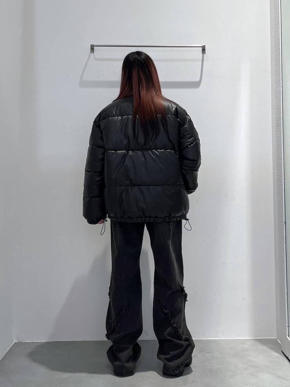 ブラック系のダウンジャケット/コート、レッド系のニット/セーター、ブラック系のその他パンツを着用したレディースの冬コーディネートの3枚目の写真