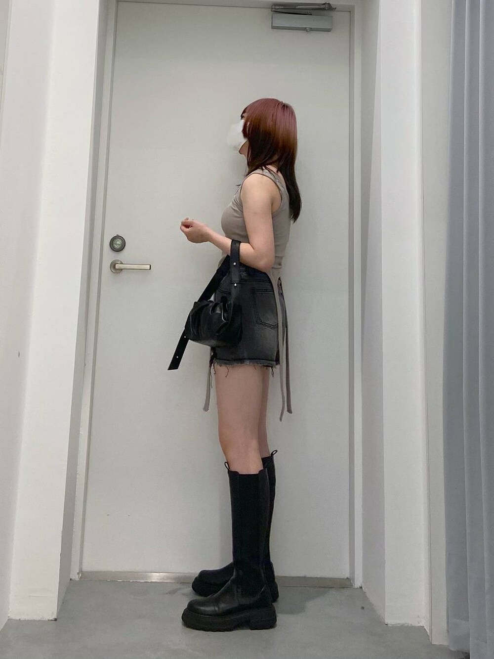 ブラック系のトートバッグ、ブラック系のデニムパンツを着用したレディースの春コーディネートの4枚目の写真