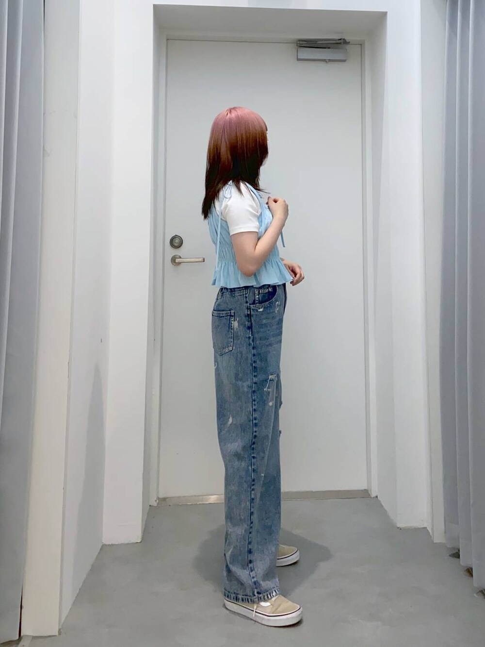 ブルー系のデニムパンツ、ホワイト系のTシャツ/カットソー、ブルー系のキャミソールを着用したレディースの春コーディネートの3枚目の写真