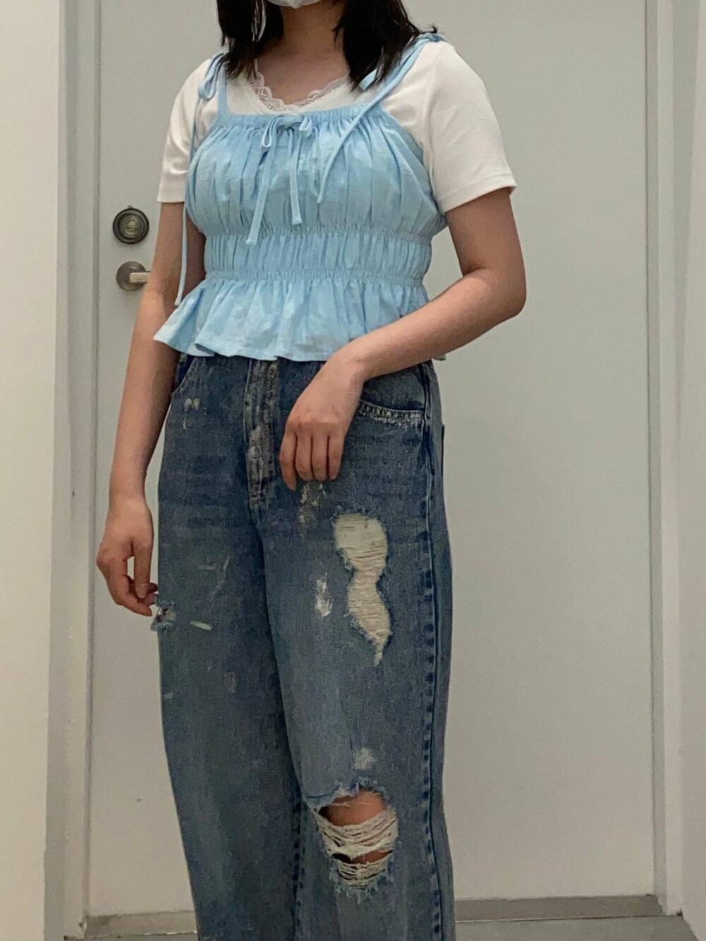 ブルー系のデニムパンツ、ホワイト系のTシャツ/カットソー、ブルー系のキャミソールを着用したレディースの春コーディネートの4枚目の写真