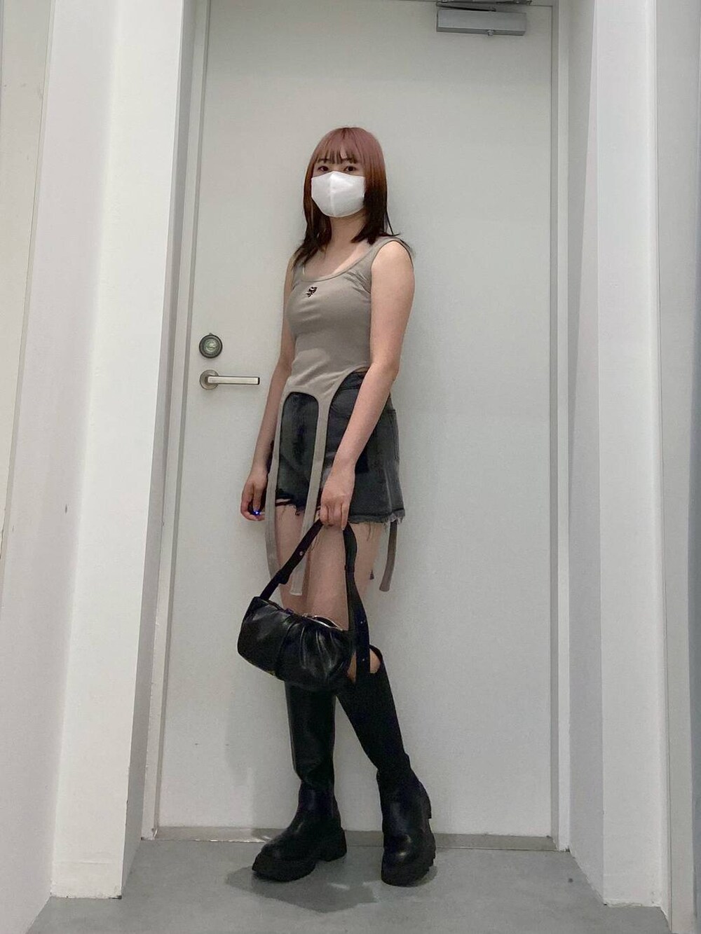 ブラック系のトートバッグ、ブラック系のデニムパンツを着用したレディースの春コーディネートの2枚目の写真