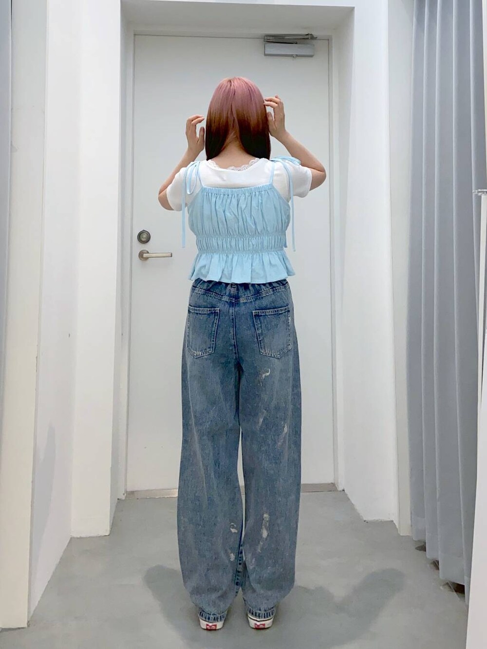 ブルー系のデニムパンツ、ホワイト系のTシャツ/カットソー、ブルー系のキャミソールを着用したレディースの春コーディネートの2枚目の写真