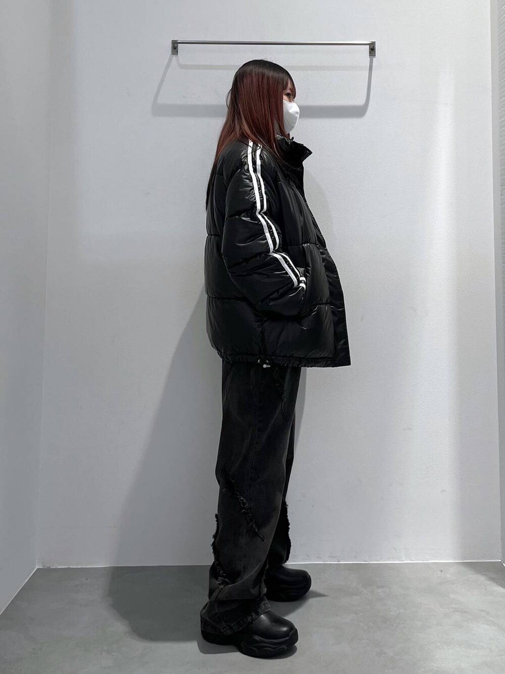 ブラック系のダウンジャケット/コート、レッド系のニット/セーター、ブラック系のその他パンツを着用したレディースの冬コーディネートの2枚目の写真