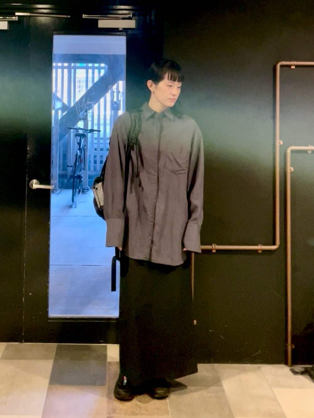 ブラック系のスニーカー、ブルー系のシャツ/ブラウス、ブラック系のスカートを着用したレディースの秋コーディネートの2枚目の写真