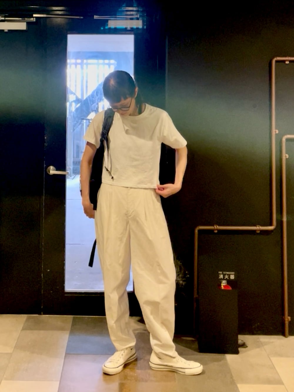 ホワイト系のTシャツ/カットソー、ホワイト系のスニーカー、ブラック系のバックパック/リュックを着用したレディースの夏コーディネートの2枚目の写真