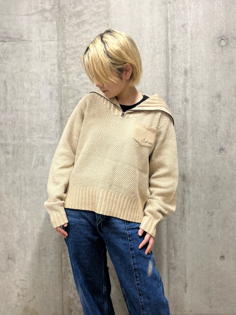 ホワイト系のニット/セーター、ブルー系のデニムパンツを着用したレディースの秋コーディネートの3枚目の写真