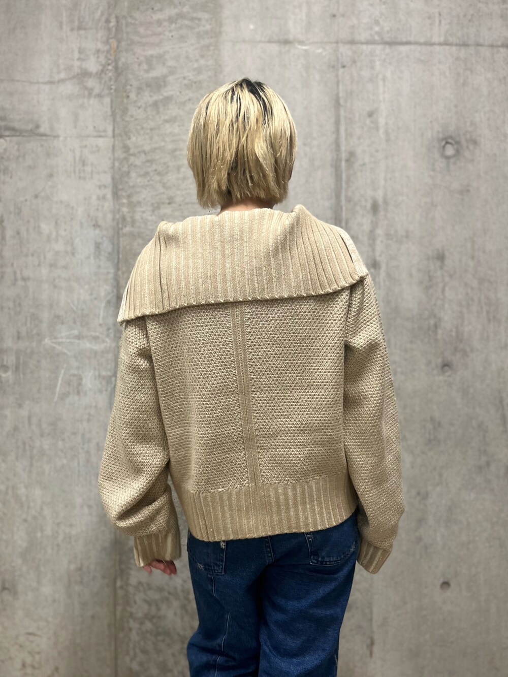 ホワイト系のニット/セーター、ブルー系のデニムパンツを着用したレディースの秋コーディネートの4枚目の写真