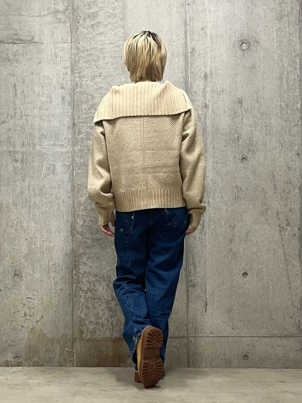 ホワイト系のニット/セーター、ブルー系のデニムパンツを着用したレディースの秋コーディネートの2枚目の写真