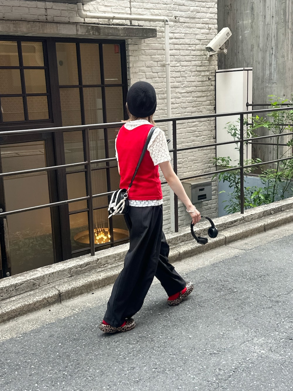 レッド系のキャミソール、ホワイト系のシャツ/ブラウス、ブラック系のスラックスを着用したレディースの夏コーディネートの4枚目の写真