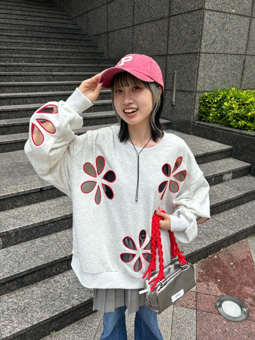 グレー系のTシャツ/カットソー、グレー系のスカート、ブルー系のデニムパンツを着用したレディースの秋コーディネートの2枚目の写真