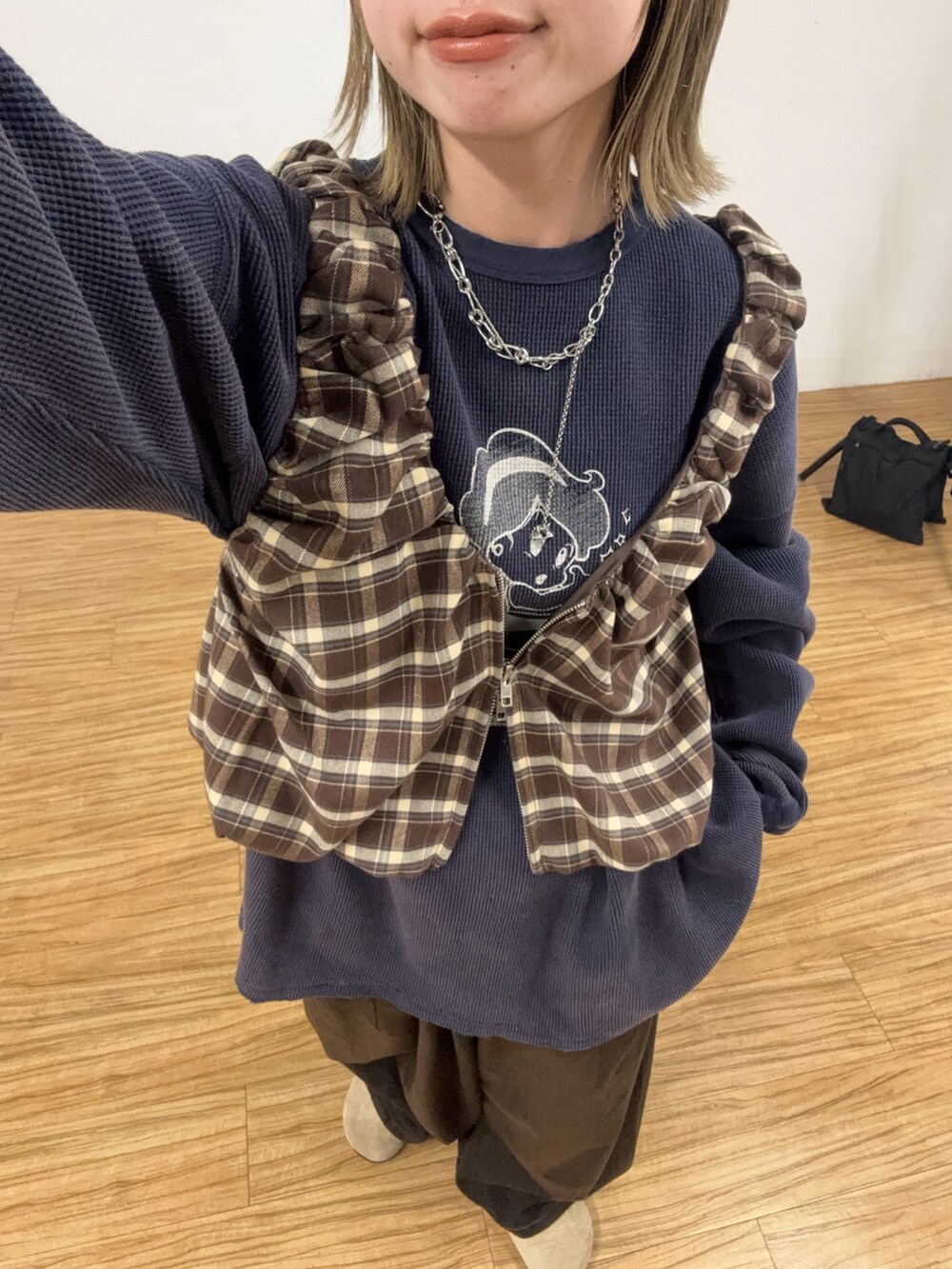 ブルー系のTシャツ/カットソー、ブラウン系のベスト、ブラウン系のデニムパンツを着用したレディースの夏コーディネートの2枚目の写真