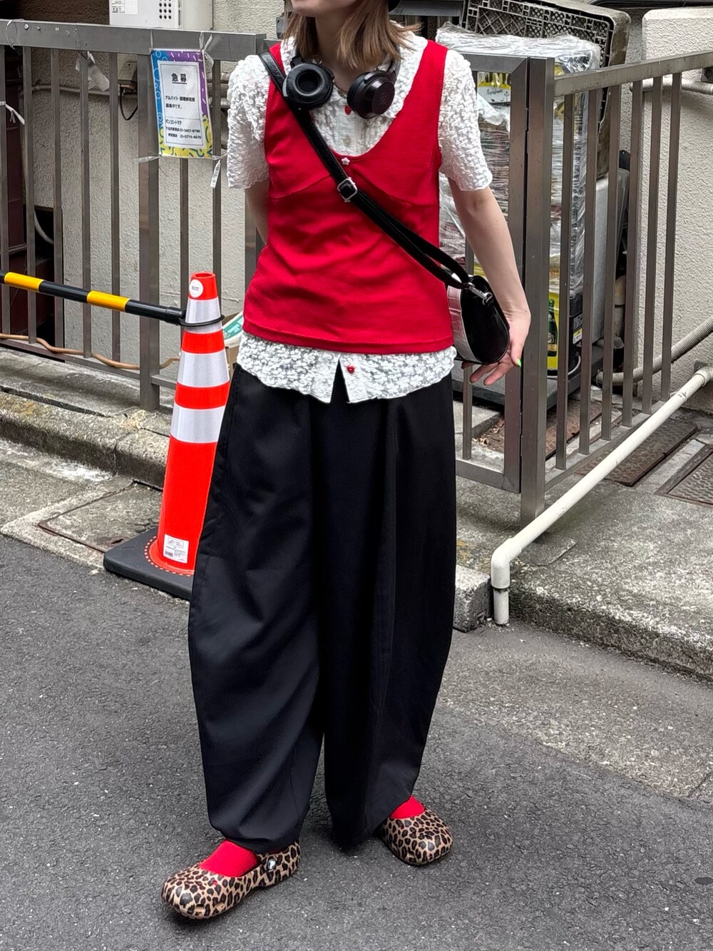 レッド系のキャミソール、ホワイト系のシャツ/ブラウス、ブラック系のスラックスを着用したレディースの夏コーディネートの2枚目の写真