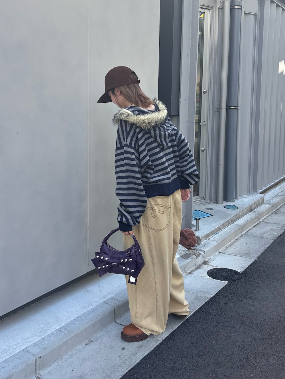ブルー系のパーカー、イエロー系のデニムパンツ、パープル系のショルダーバッグを着用したレディースの秋コーディネートの2枚目の写真