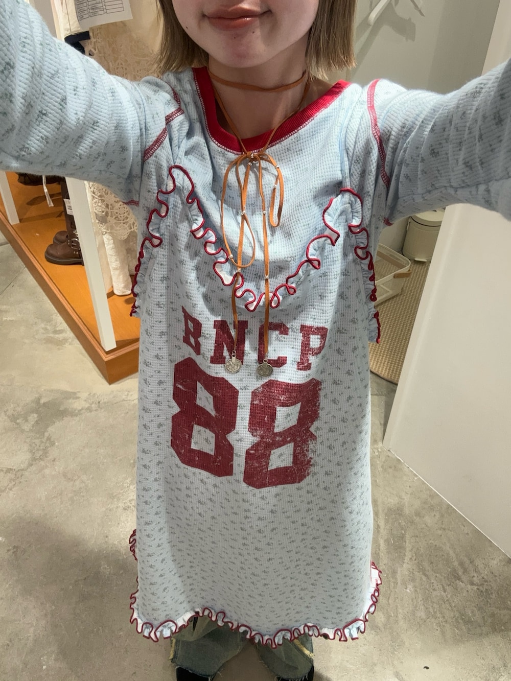 ブルー系のワンピース、ベージュ系のデニムパンツ、ブラウン系のキャップを着用したレディースの春コーディネートの2枚目の写真