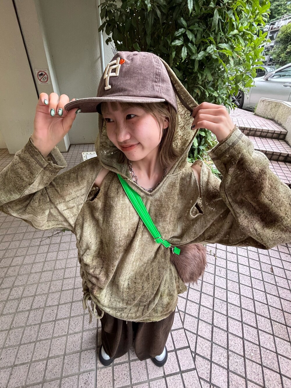 グリーン系のTシャツ/カットソー、ブラウン系のデニムパンツ、シルバー系のサンダルを着用したレディースの夏コーディネートの3枚目の写真